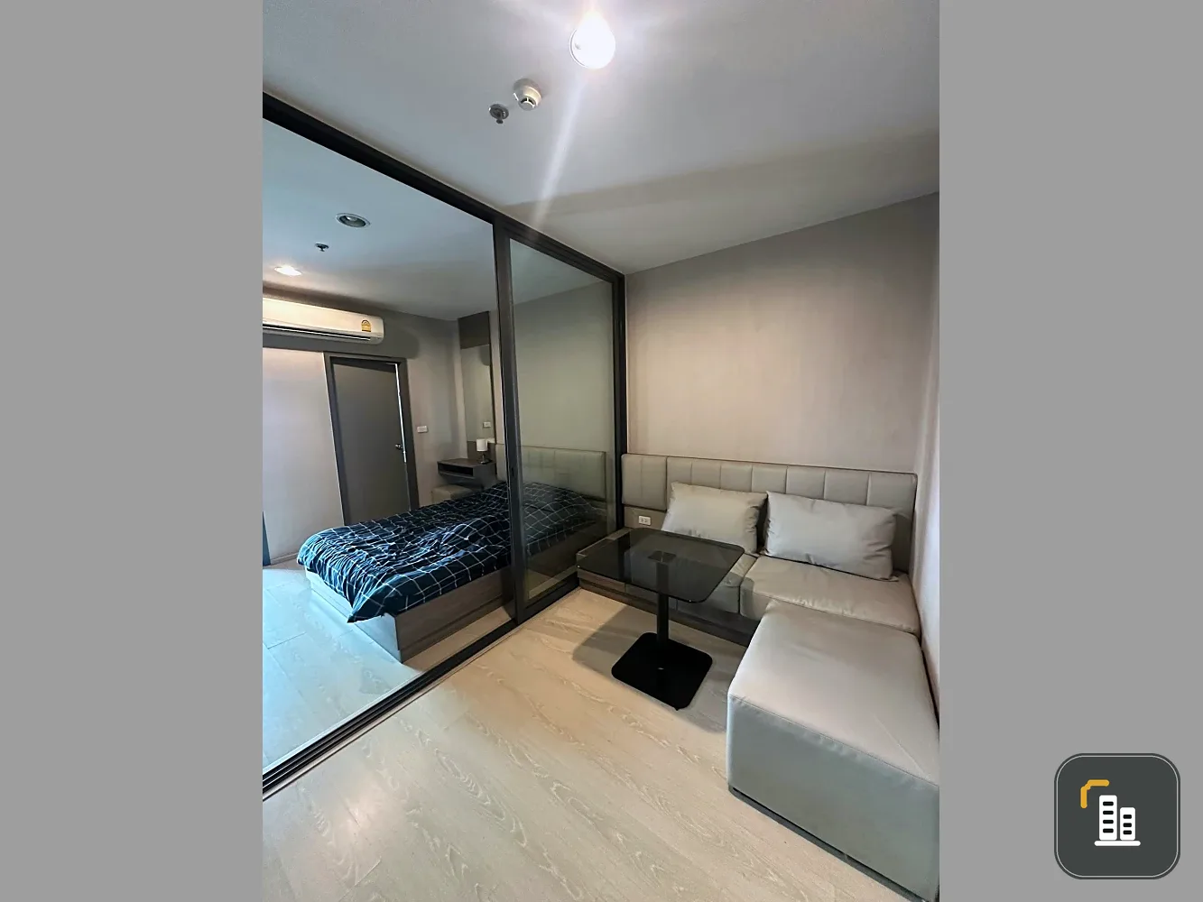 For sale: Ideo Tha Phra Interchange. Features sliding doors separating the living room and bedroom, a separate kitchen with balcony access, and built
